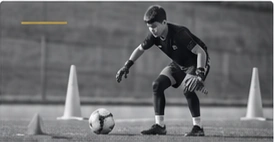 Arquero trabajando entre conos con un balón